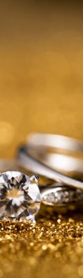 A closeup shot of two diamond rings on a golden surface